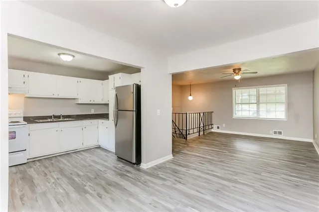 a kitchen with a refrigerator and white cabinets