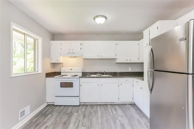 a kitchen with a white cabinets and white appliances