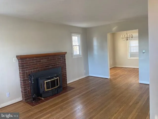 a view of empty room with wooden floor and fireplace
