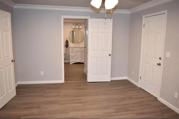 a view of a hallway with wooden floor and closet area