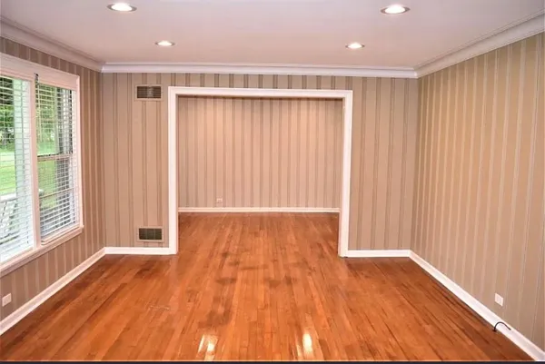 a view of a room with wooden floor and large window