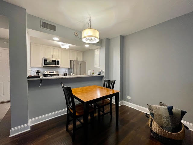509 Aurora Avenue, Unit 308 Naperville, IL 60540 - Photo 5 of 22 a kitchen with stainless steel appliances granite countertop a stove top oven a refrigerator a sink and a dining table with wooden floor