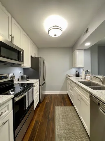 a kitchen with stainless steel appliances granite countertop a sink and stove top oven