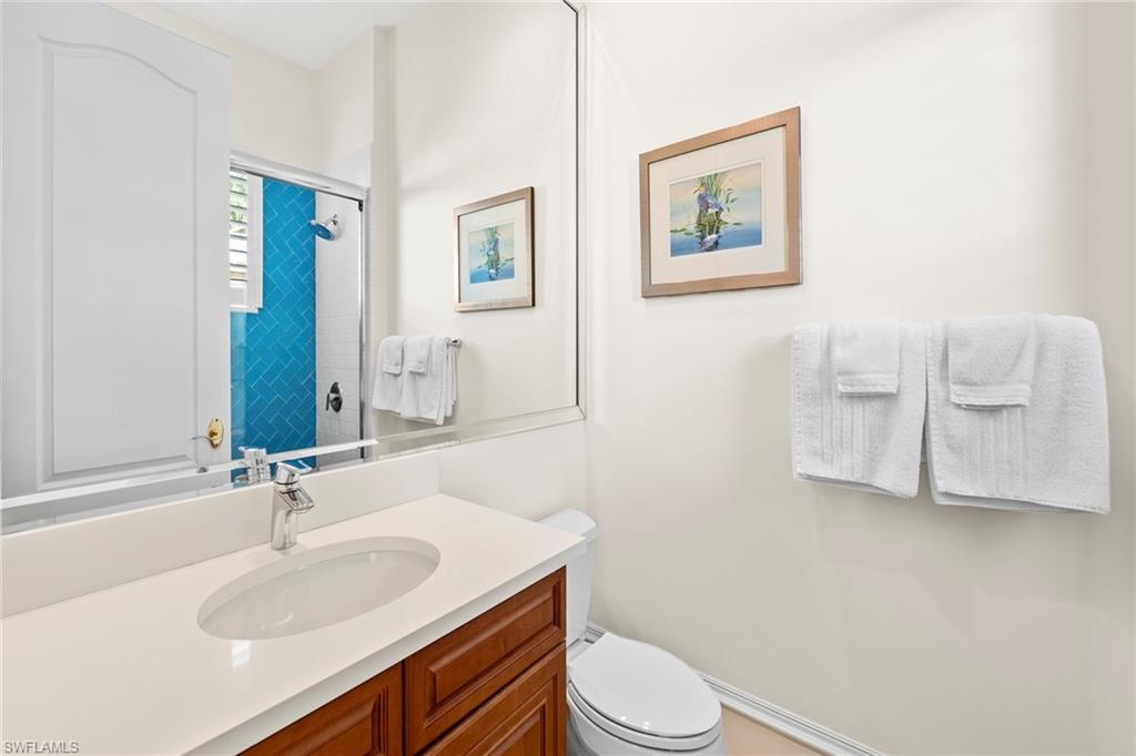 18071 Lagos Way Naples, FL 34110 - Photo 14 of 44 a bathroom with a toilet sink and mirror
