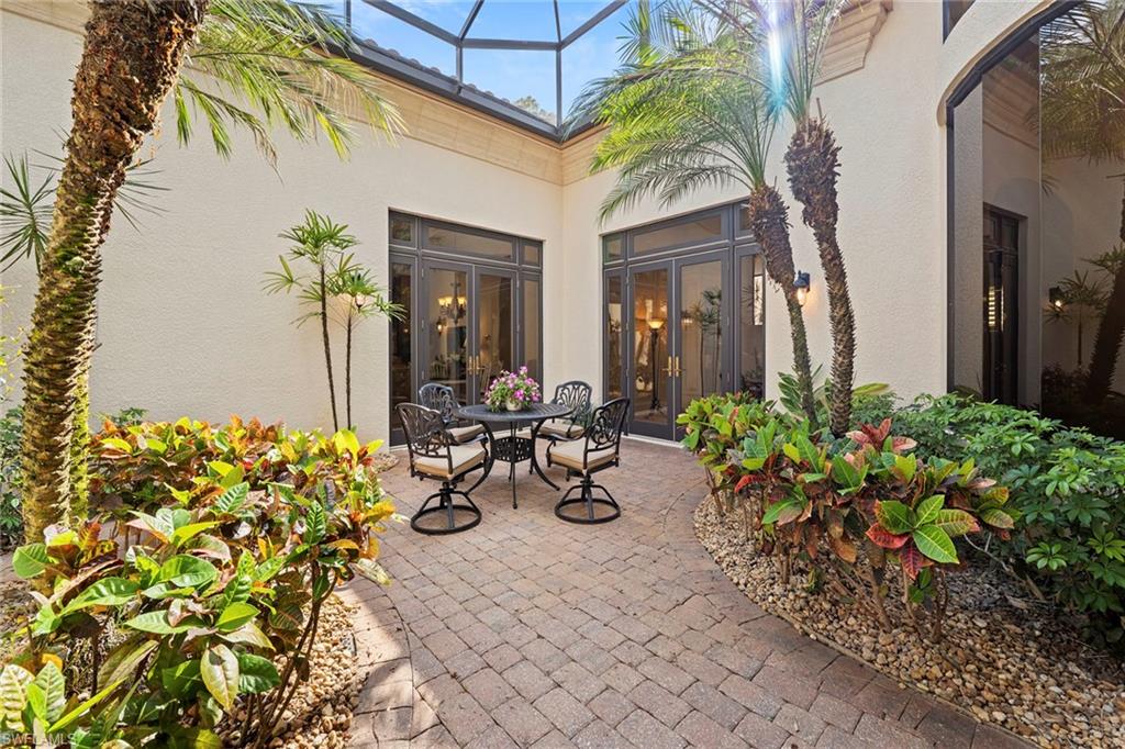 18071 Lagos Way Naples, FL 34110 - Photo 21 of 44 a view of a chair and tables in the patio