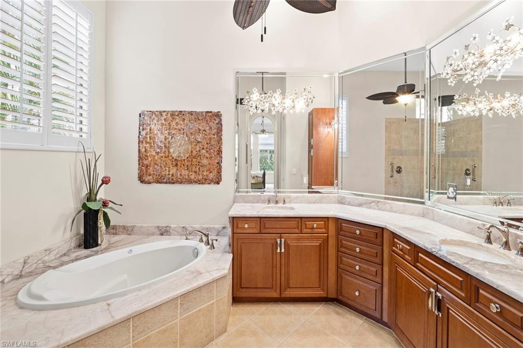 18071 Lagos Way Naples, FL 34110 - Photo 34 of 44 a spacious bathroom with a granite countertop sink and a mirror