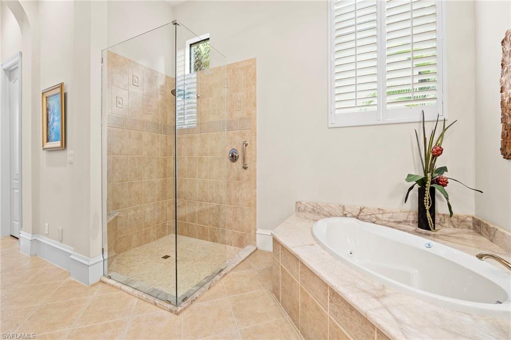 18071 Lagos Way Naples, FL 34110 - Photo 36 of 44 a bathroom with a granite countertop sink a mirror and a glass door shower