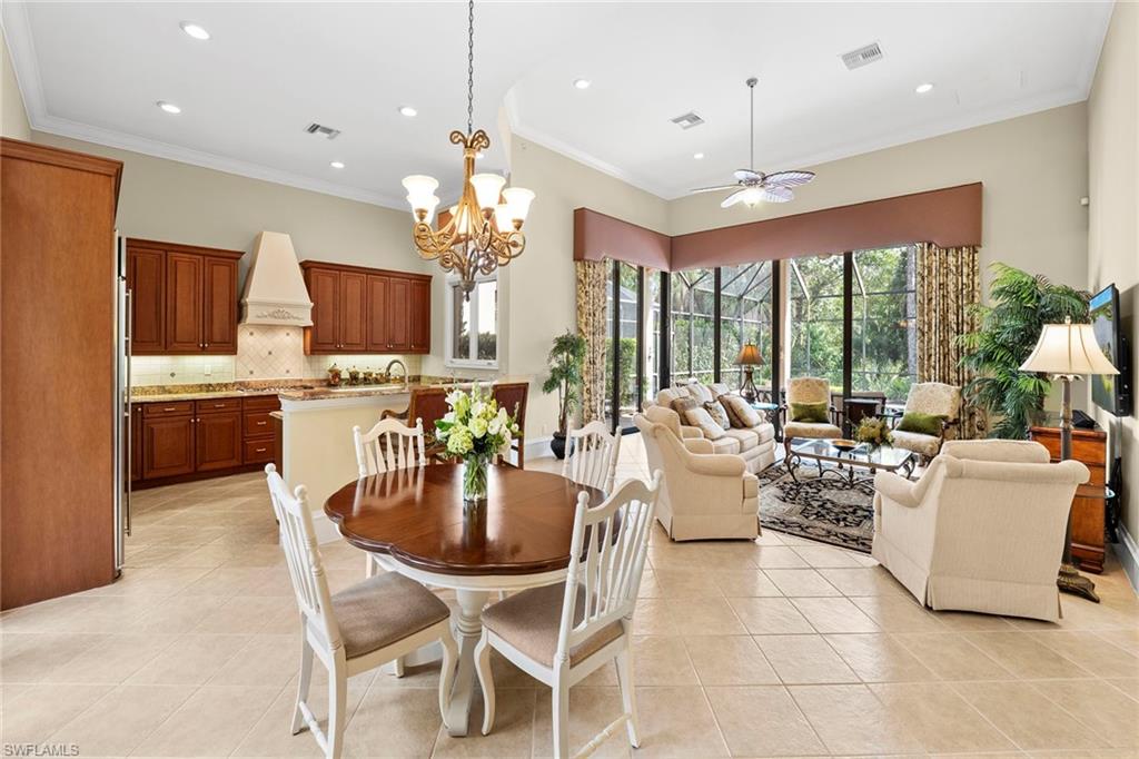 18071 Lagos Way Naples, FL 34110 - Photo 7 of 44 a kitchen with a dining table wooden floor and a chandelier