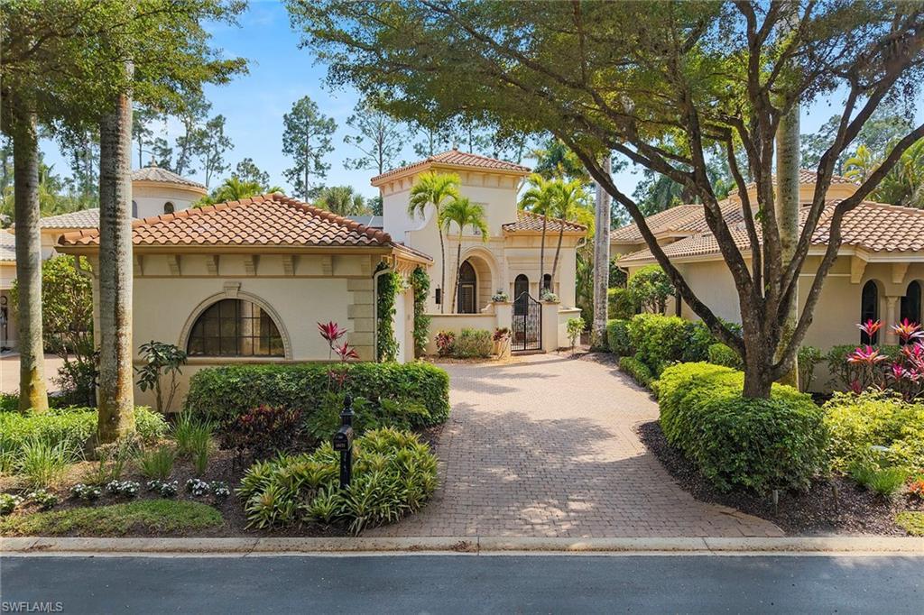 18071 Lagos Way Naples, FL 34110 - Photo 8 of 44 a front view of a house with garden