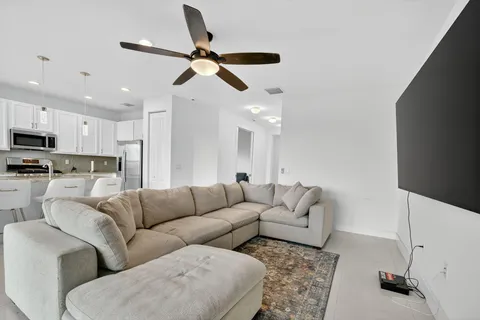 a living room with furniture and kitchen view