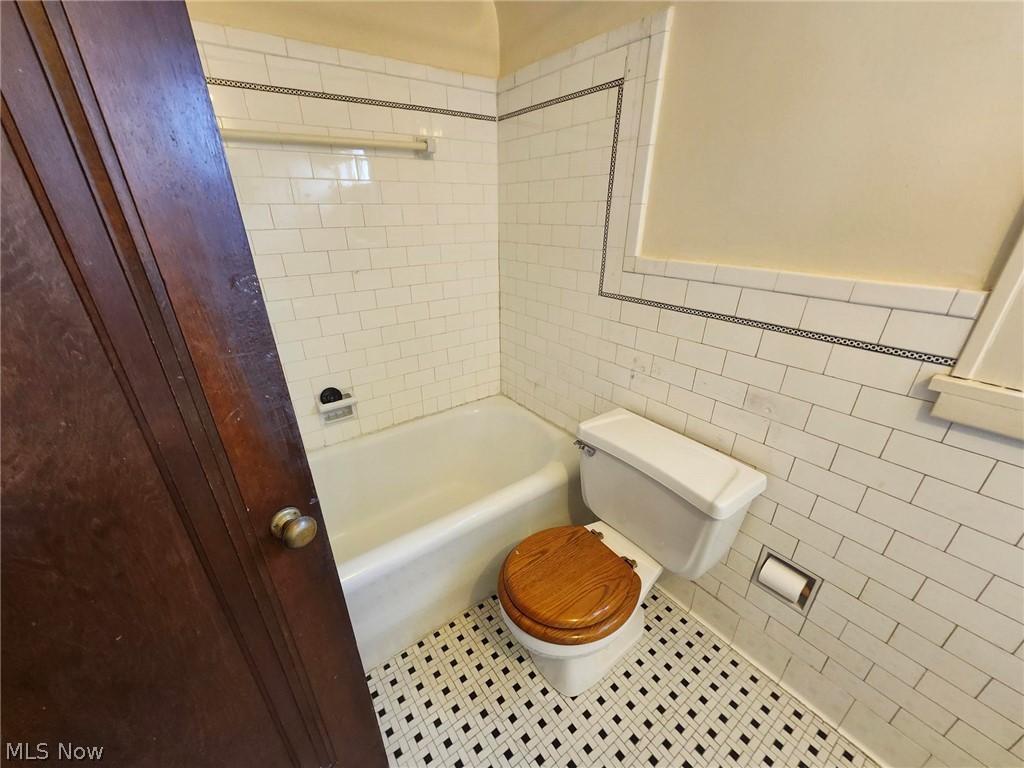 3819 Woodridge Road Cleveland Heights, OH 44121 - Photo 18 of 42 Bathroom featuring tile walls, tile patterned floors, toilet, and tiled shower / bath