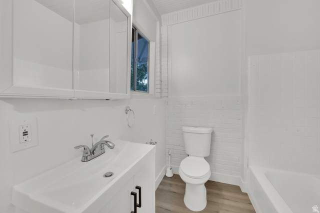 197 West Center Street Midvale, UT 84047 - Photo 9 of 12 Bathroom with vanity, light wood-style floors, and wainscoting