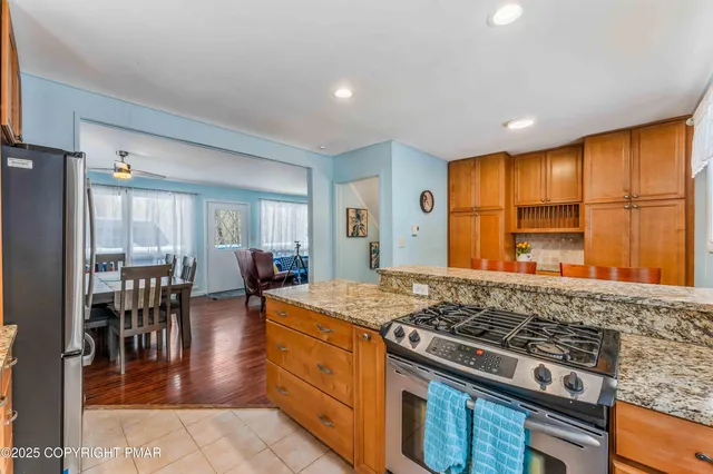 a kitchen with stainless steel appliances granite countertop a stove top oven a sink dishwasher and cabinets with wooden floor