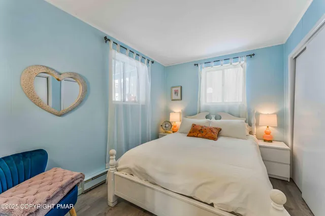 a bedroom with a bed a mirror and a window