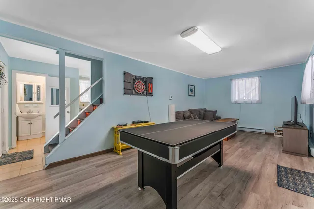 a room with furniture pool table and windows