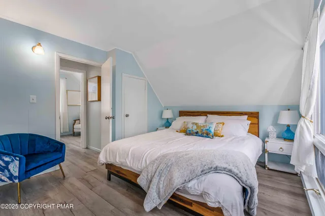 a bedroom with a bed a mirror and couch