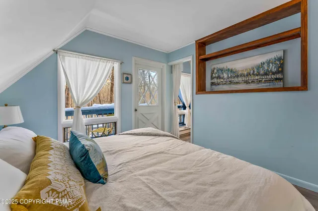 a bedroom with a bed a couch and a large window