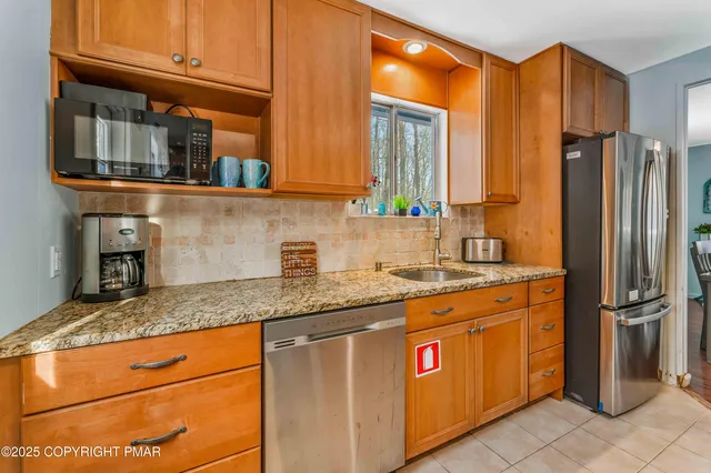 a kitchen with stainless steel appliances granite countertop a refrigerator a sink and dishwasher