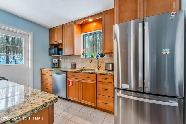 a kitchen with stainless steel appliances granite countertop a refrigerator and a sink