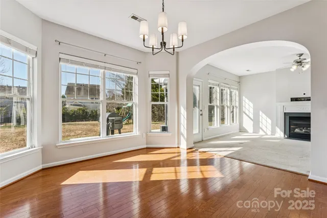 a kitchen with stainless steel appliances white cabinets and a stove a refrigerator with wooden floor