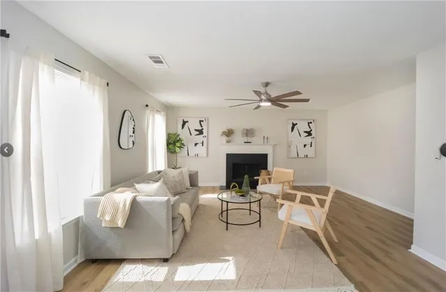 a living room with furniture a fireplace and a window