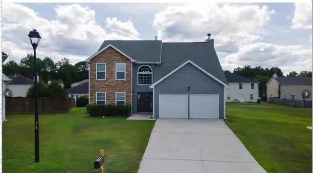 a front view of house with yard and green space