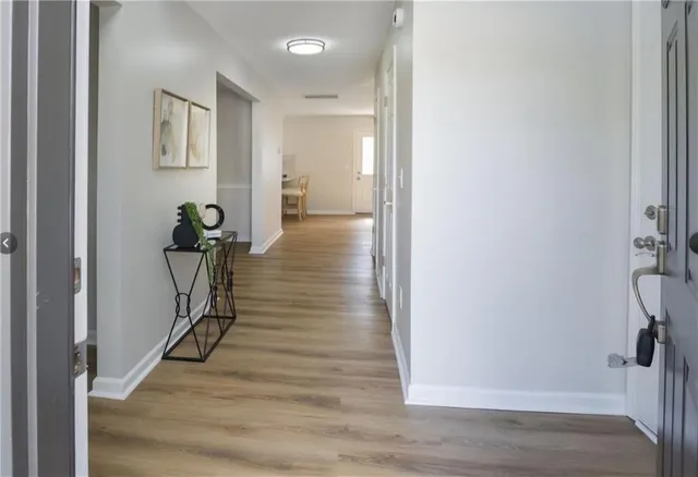 a view of a hallway with wooden floor and staircase