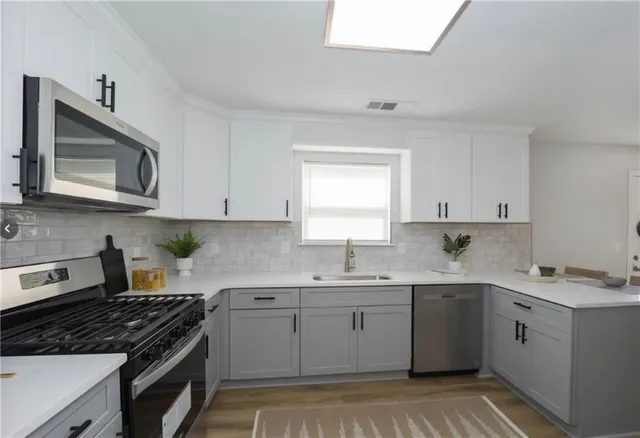 a kitchen with a sink stove top oven and cabinets