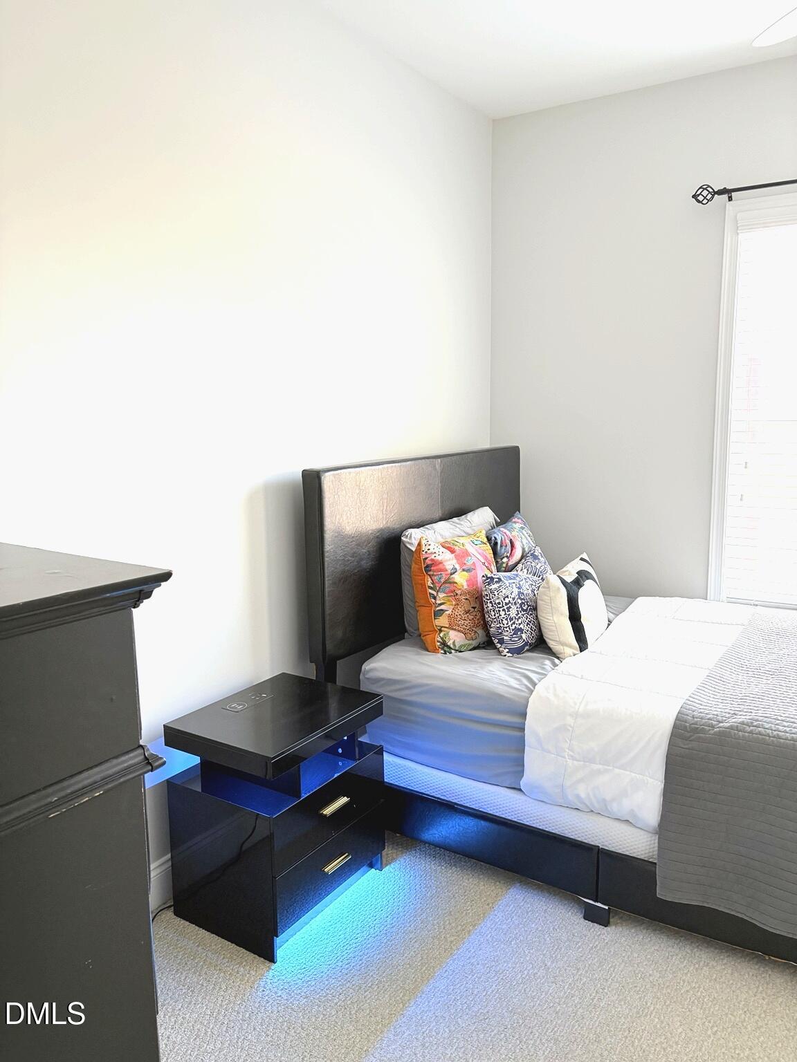 9211 Calabria Drive, Unit 117 Raleigh, NC 27617 - Photo 11 of 19 a bedroom with a bed and a potted plant on dresser