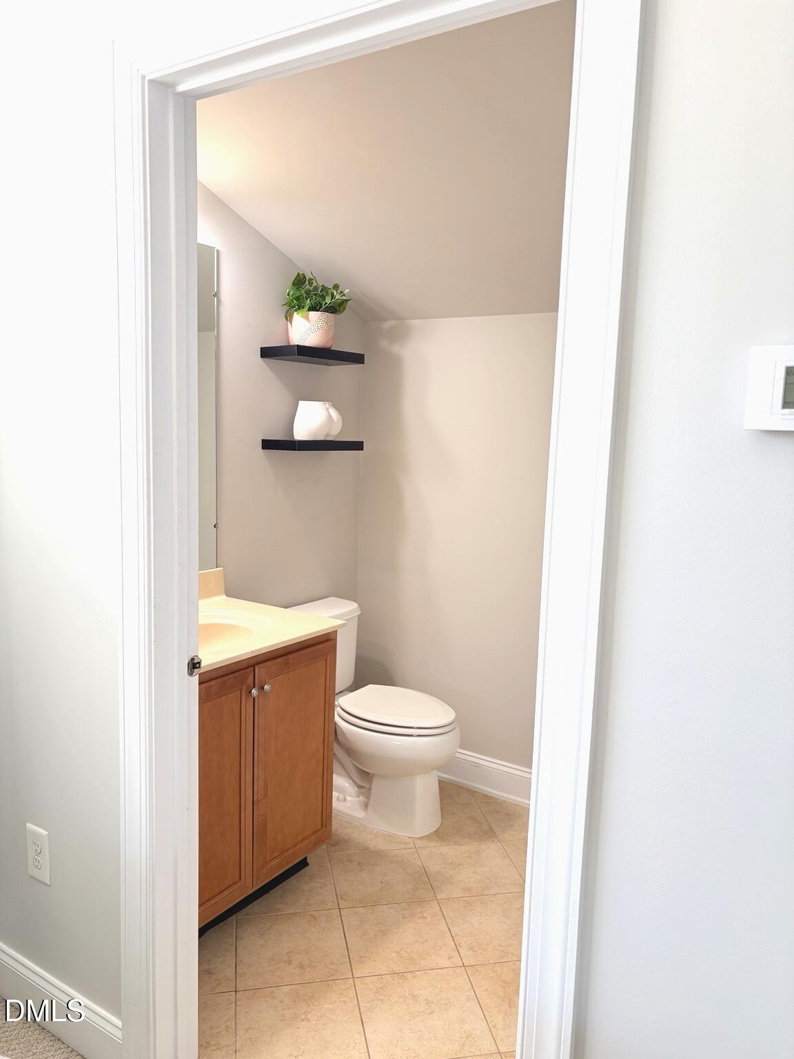 9211 Calabria Drive, Unit 117 Raleigh, NC 27617 - Photo 13 of 19 a bathroom with a granite countertop toilet and a sink
