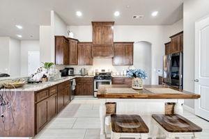25280 Grove Way Madera, CA 93638 - Photo 13 of 32 a kitchen with kitchen island granite countertop a sink and refrigerator