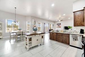 25280 Grove Way Madera, CA 93638 - Photo 15 of 32 a kitchen with stainless steel appliances kitchen island granite countertop a table chairs sink and cabinets