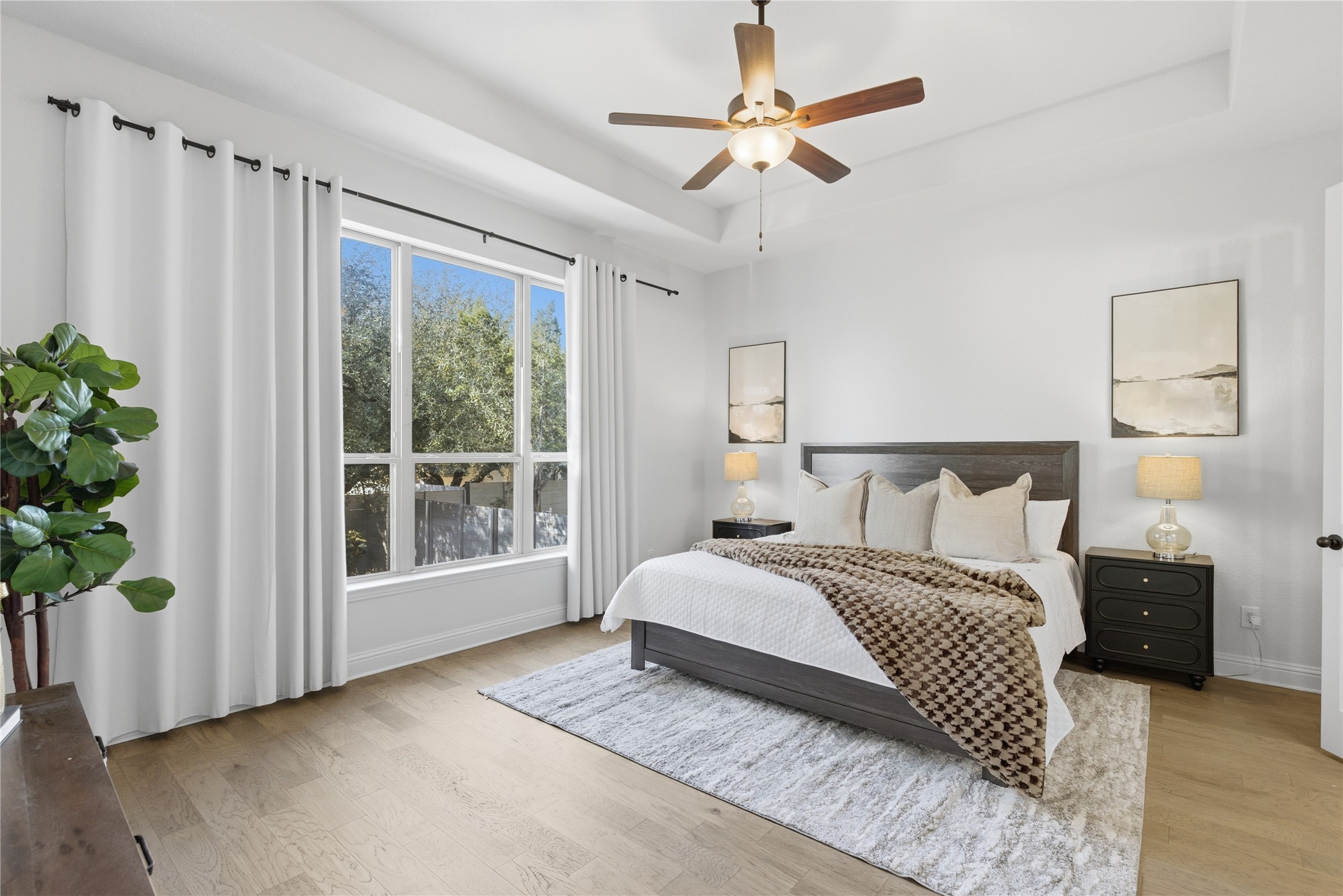 225 Diamondback Drive Georgetown, TX 78628 - Photo 17 of 39 Bedroom featuring light wood finished floors, a ceiling fan, and a tray ceiling.
