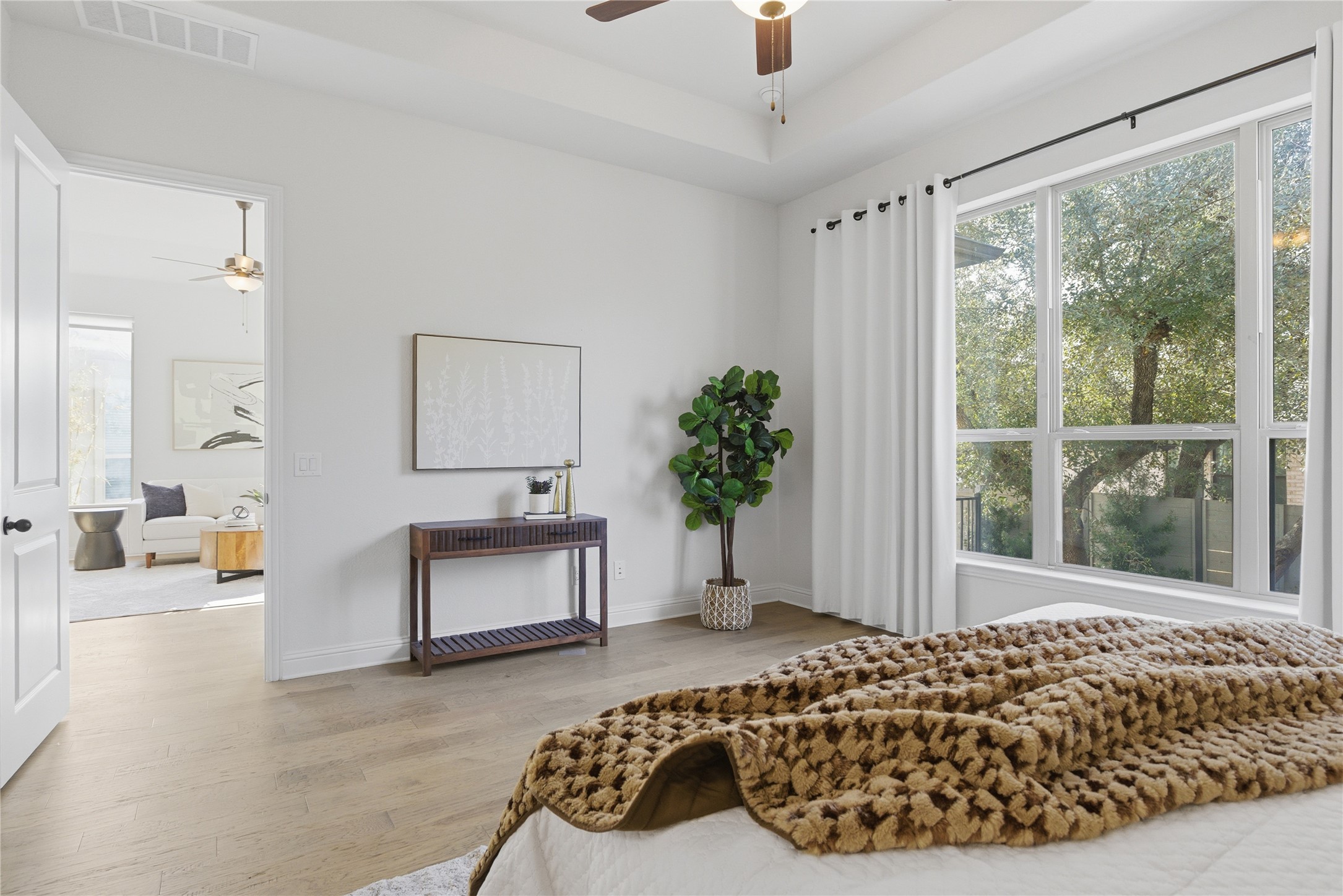 225 Diamondback Drive Georgetown, TX 78628 - Photo 18 of 40 Bedroom featuring wood finished floors, a tray ceiling, and ceiling fan.
