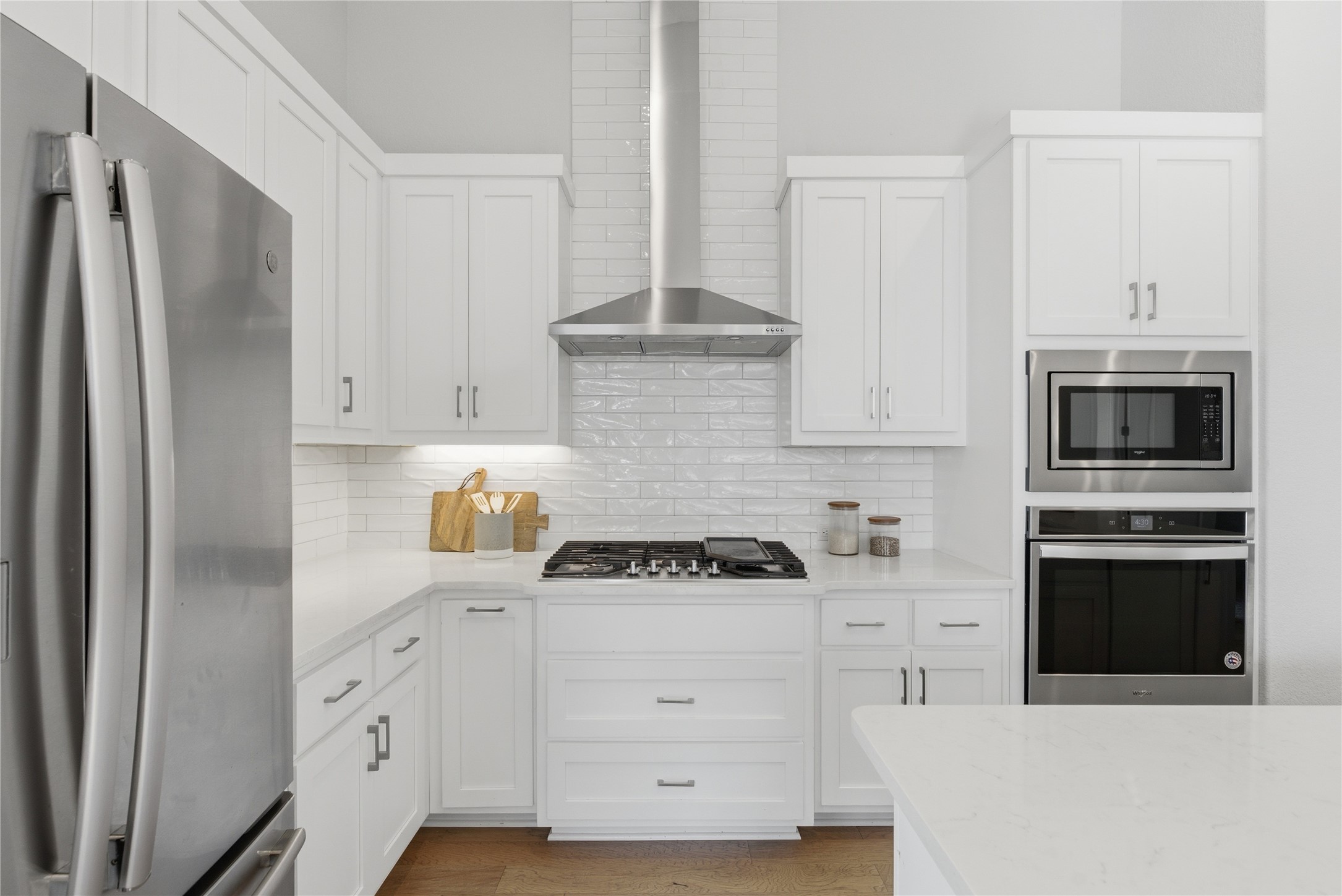 225 Diamondback Drive Georgetown, TX 78628 - Photo 9 of 39 Kitchen with stainless steel appliances, light stone counters, white cabinets, and light wood-style flooring