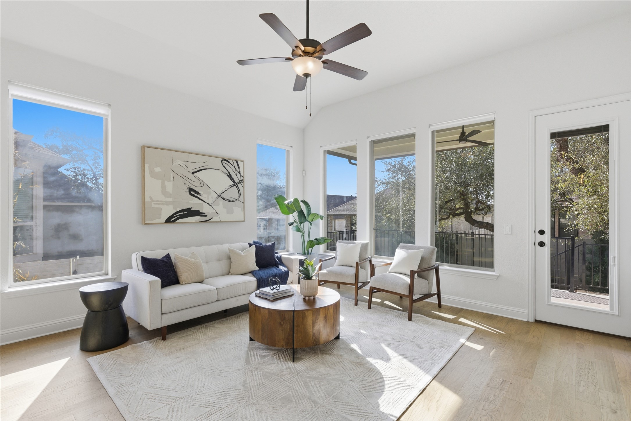225 Diamondback Drive Georgetown, TX 78628 - Photo 10 of 40 Living area featuring light wood finished floors, ceiling fan, healthy amount of natural light, high ceiling and a wall of windows allowing for natural lighting.