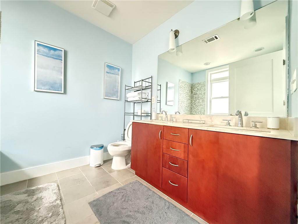 3655 Peachtree Road Northeast, Unit 304 Atlanta, GA 30319 - Photo 22 of 36 a bathroom with a granite countertop toilet sink and mirror