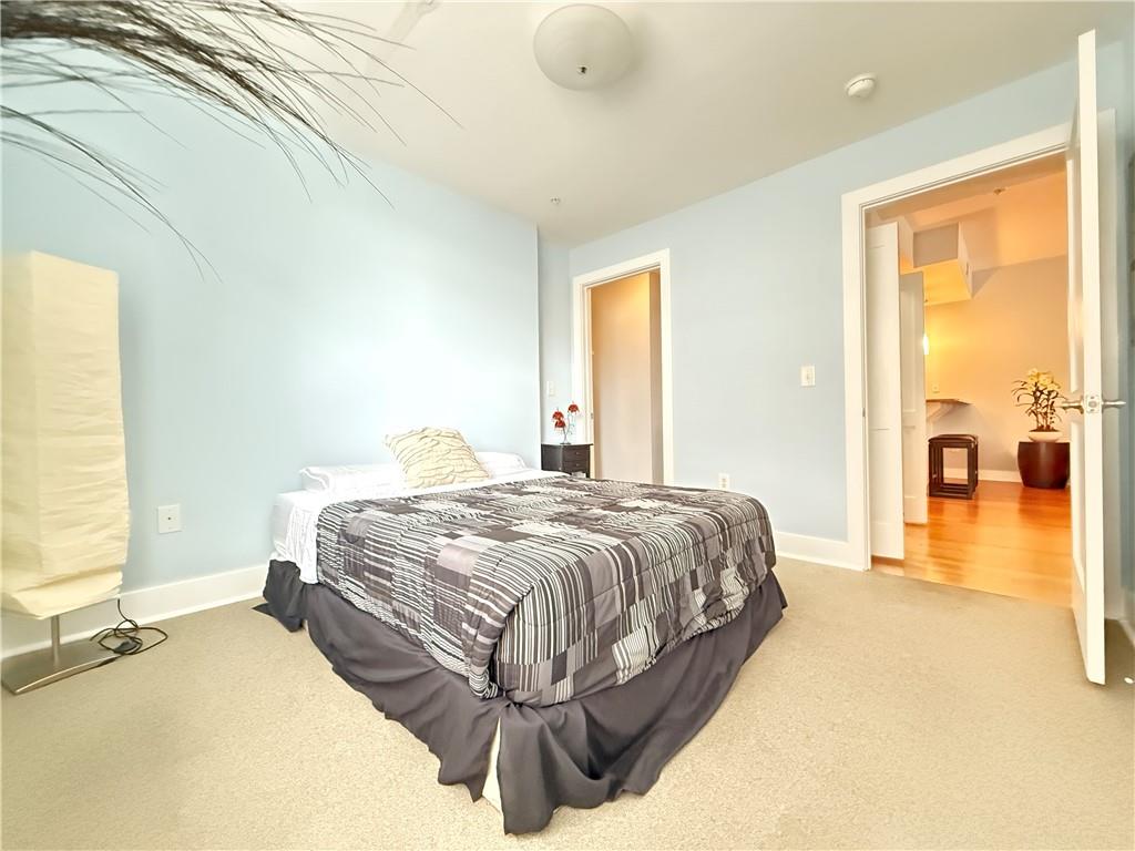 3655 Peachtree Road Northeast, Unit 304 Atlanta, GA 30319 - Photo 27 of 36 a bedroom with a bed and wooden floor