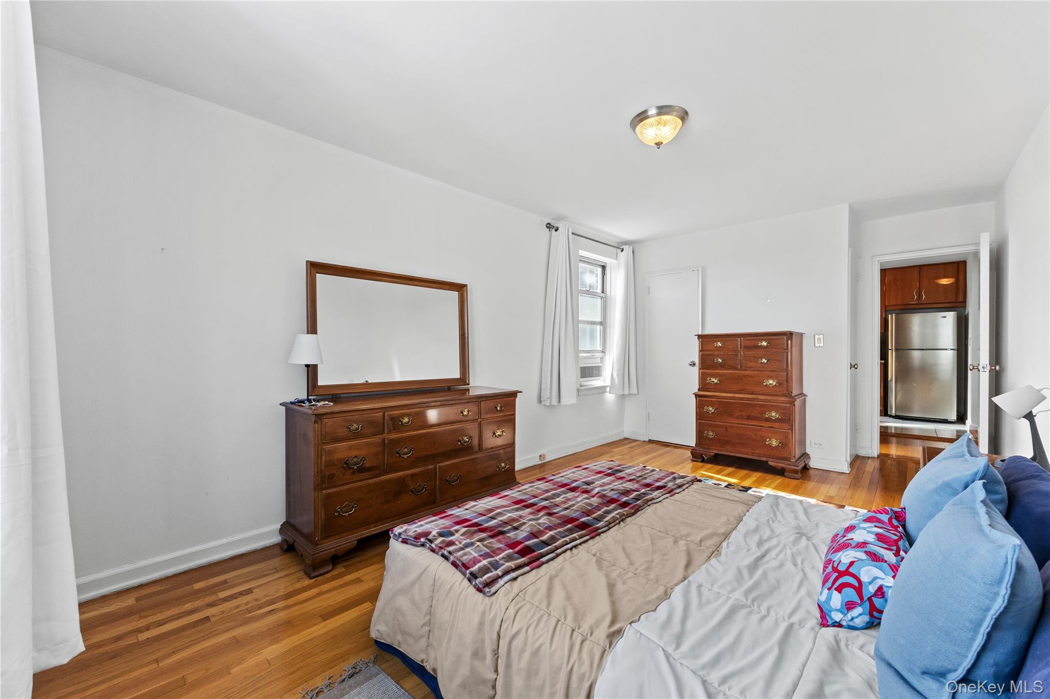 325 East 201st Street, Unit 5F Bronx, NY 10458 - Photo 12 of 19 a bedroom with a bed and dresser with mirror