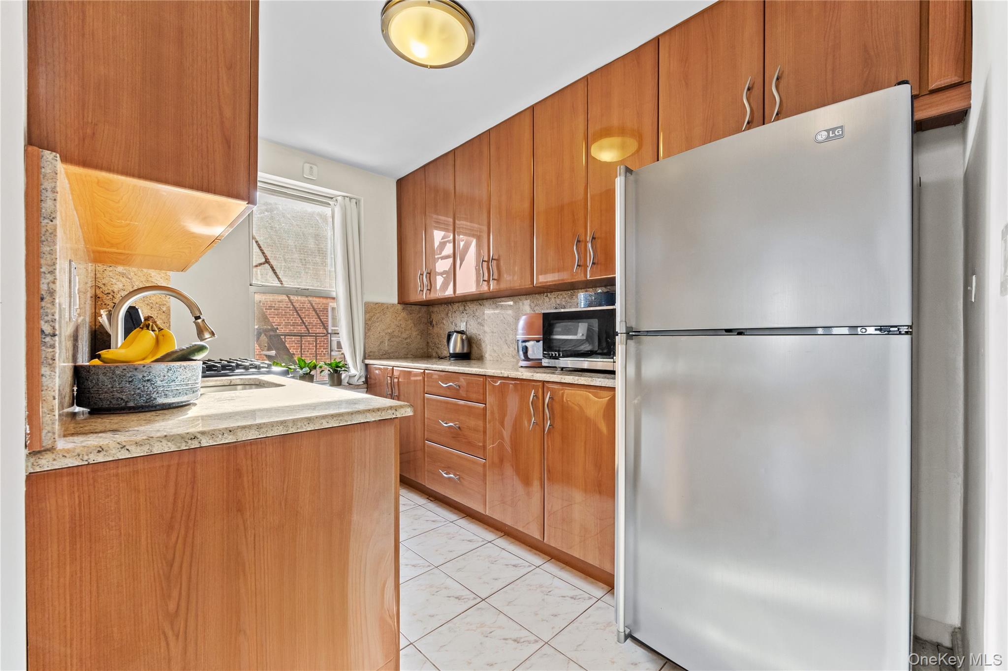 325 East 201st Street, Unit 5F Bronx, NY 10458 - Photo 6 of 19 a kitchen with a refrigerator a sink and a window