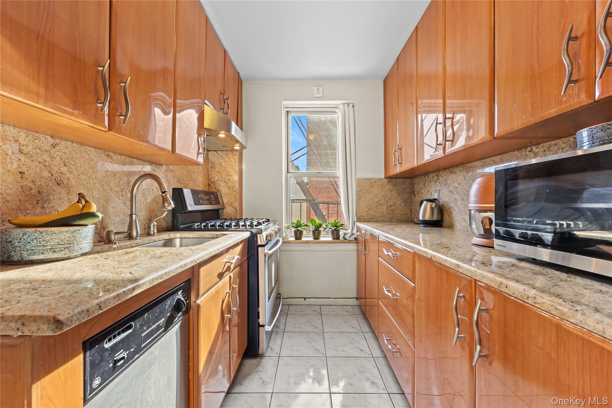 325 East 201st Street, Unit 5F Bronx, NY 10458 - Photo 7 of 19 a kitchen with stainless steel appliances granite countertop a sink and a stove
