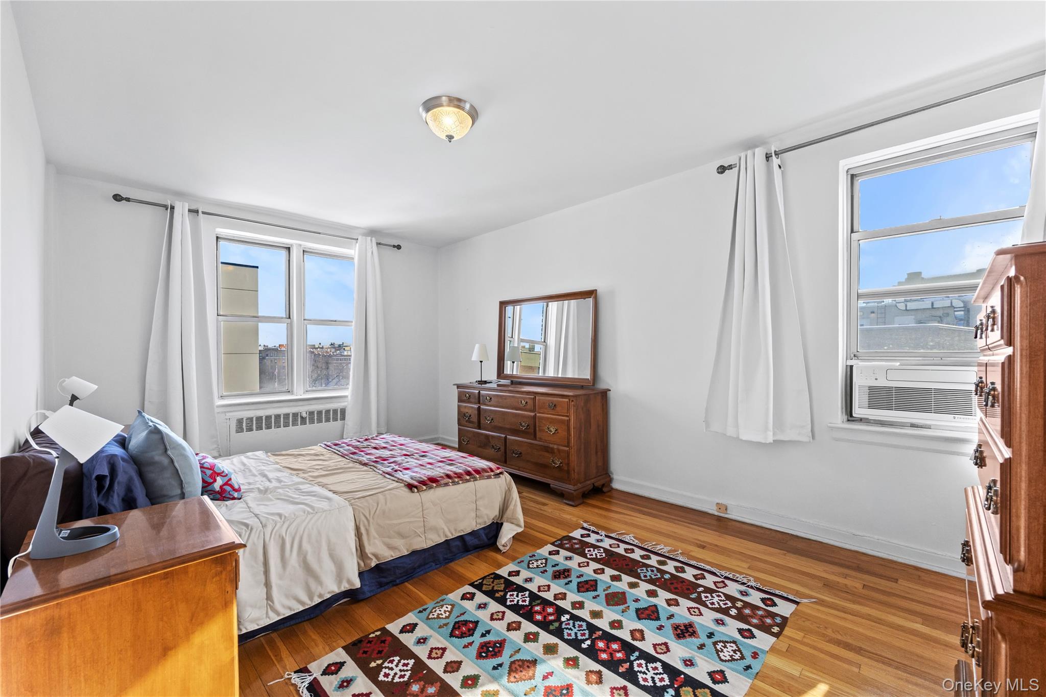 325 East 201st Street, Unit 5F Bronx, NY 10458 - Photo 10 of 19 a bedroom with a bed and wooden floor