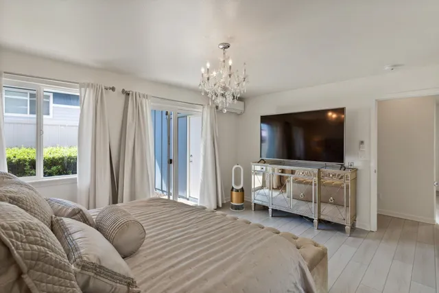 a bedroom with a large bed and a chandelier