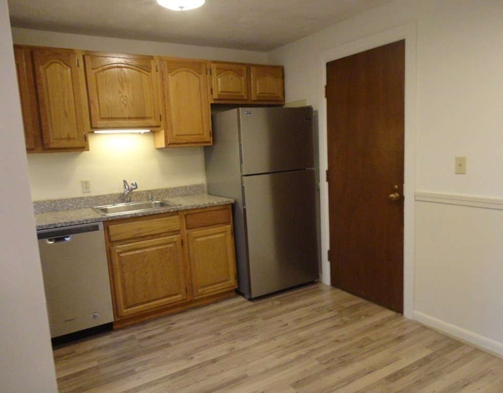 209 Great Road, Unit A 4 Acton, MA 01720 - Photo 2 of 14 a kitchen with a refrigerator sink and cabinets