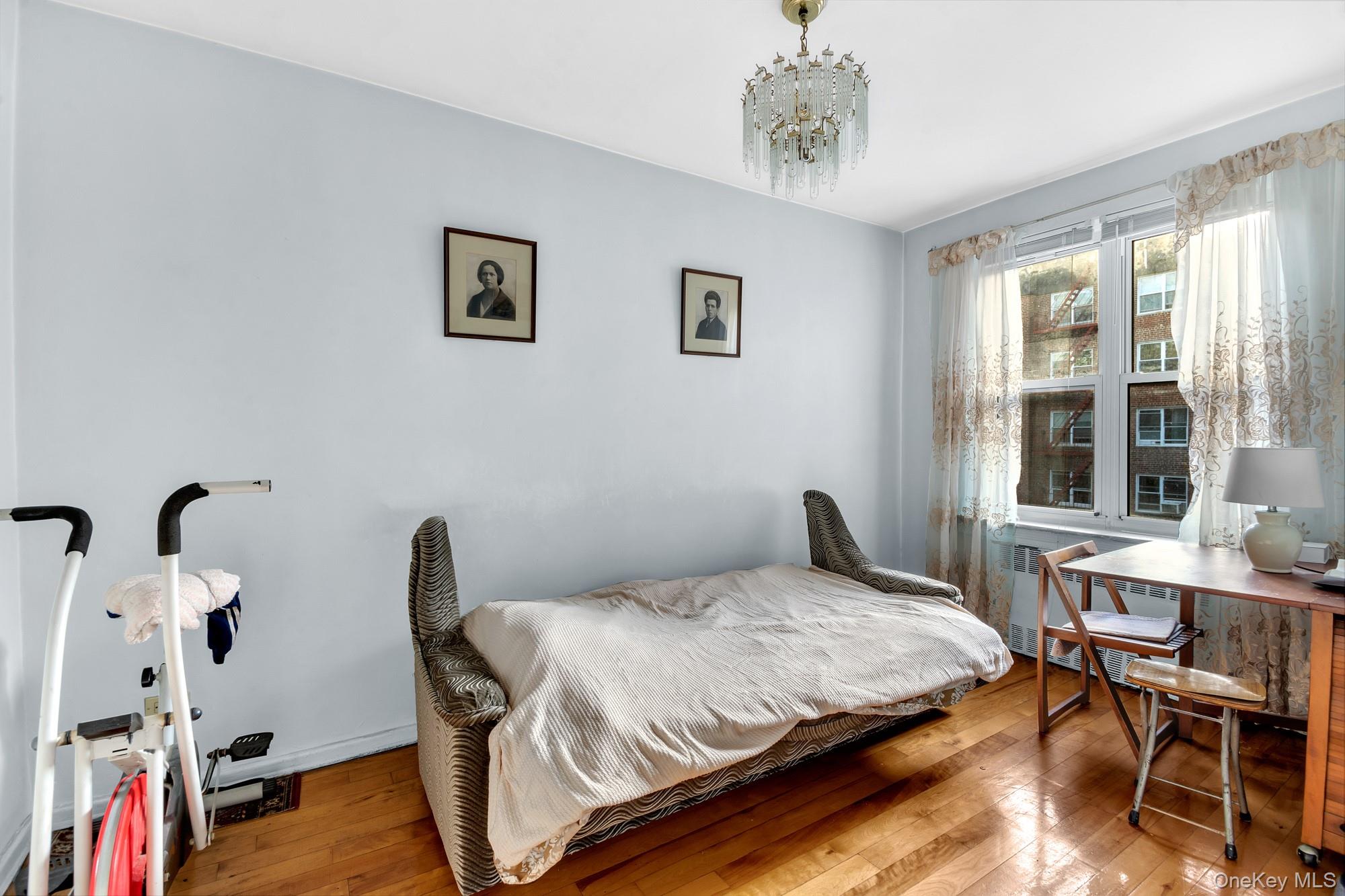 33-26 82nd Street, Unit 4C Queens, NY 11372 - Photo 5 of 10 a bedroom with a bed and a table in it