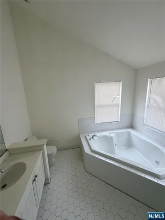 a spacious bathroom with a granite countertop sink and bathtub