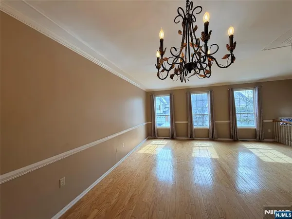 a view of a room with wooden floor chandelier