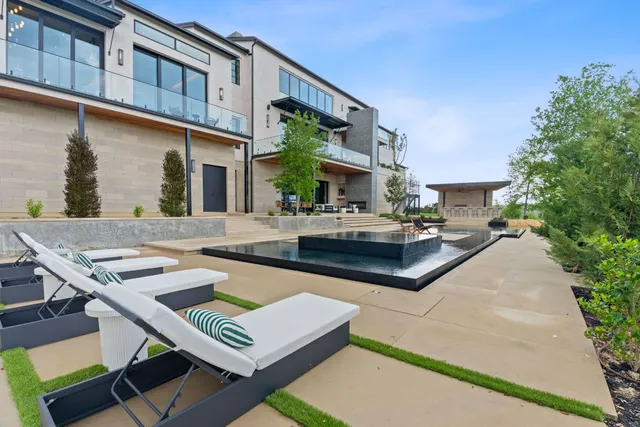 a patio with a table and chairs and potted plants