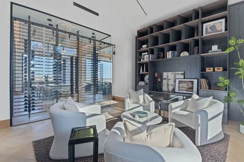 a living room with furniture a bookshelf and a large window