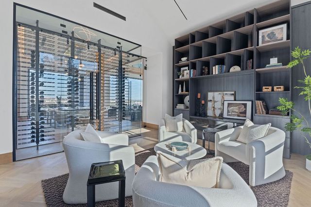 a living room with furniture a bookshelf and a large window